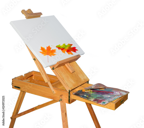 Wooden easel and autumn leaves on the empty canvas