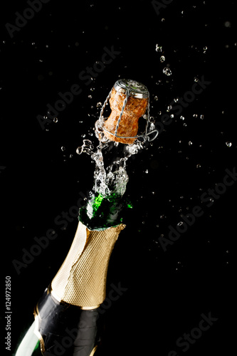 Bottle of champagne exploding isolated on black background
