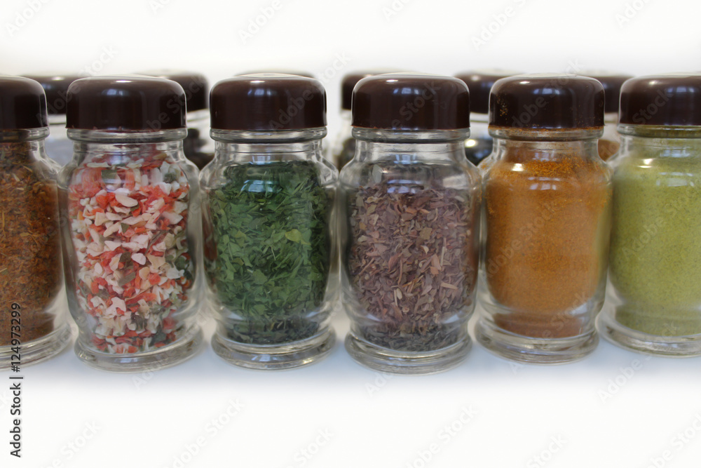 Spices in glass jars on a white background Spices in glass jars on a white background