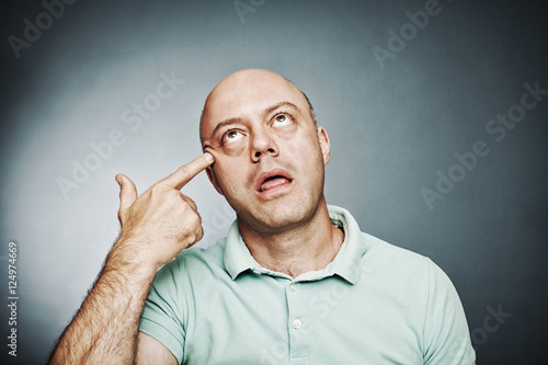  close-up, a man pointing his finger to his head in a shoot hims photo