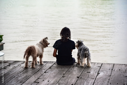 The girl and the dog sitting on Wooden floor at Waterfront home photo