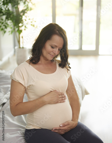 Pregnant woman stroking her abdomen