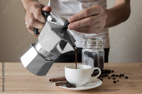 Pouring coffee out of italian coffee pot photo