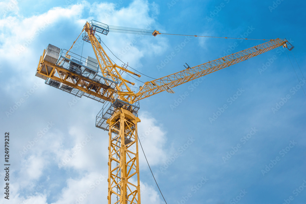 Tower crane - used in construction site with blue sky and clouds Tower crane - used in construction site with blue sky and clouds