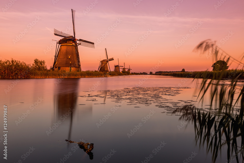 Colorful autumn scene in the famous Kinderdijk canals with windmills. Sunset in Dutch village Kinderdijk, Netherlands, Europe.