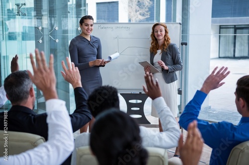 Canvas-taulu Colleagues raising their hands during meeting