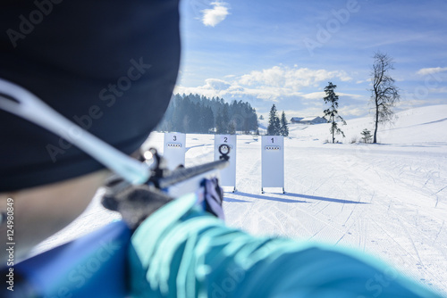 Biathletin beim anvisieren einer Zielscheibe