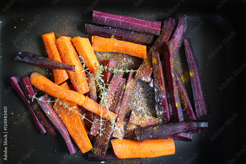 red and yellow carrots in a pan with herbs