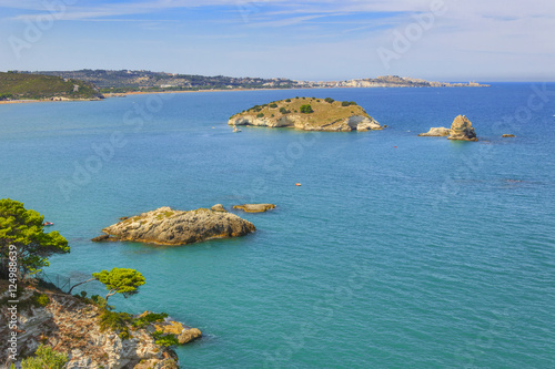 Summertime. The most beautiful coasts of Italy: bay of Vieste.-(Apulia, Gargano) -In the foreground  Gattarella or Portonuovo islet and in the background the town of Vieste. photo