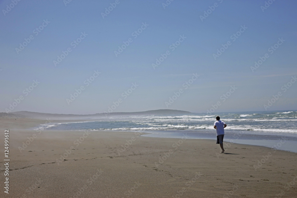 man running on wide beach