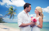 happy couple with flowers over beach background