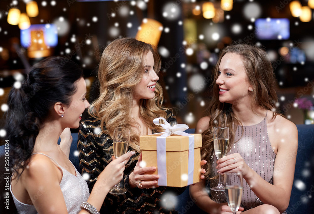 happy women with champagne and gift at night club happy women with champagne and gift at night club