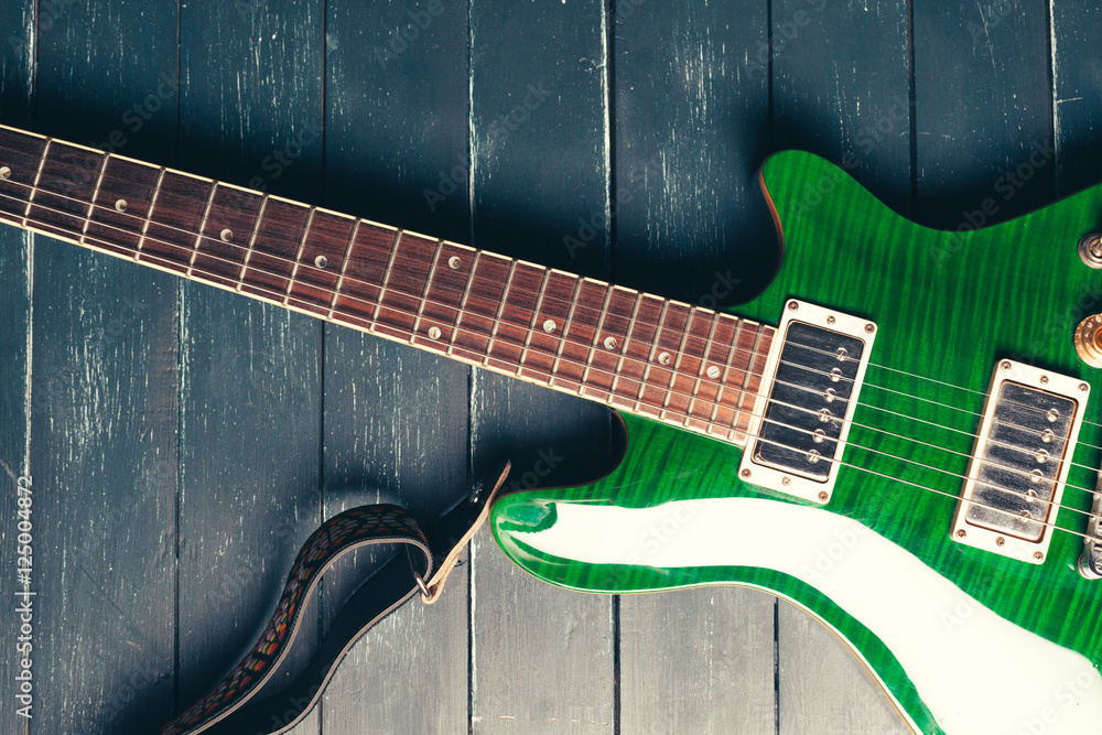 Fototapeta premium Electric guitar body and neck detail on wooden background