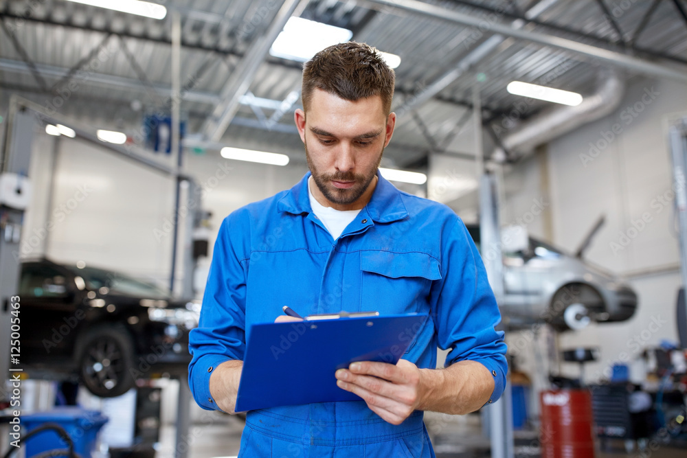 auto mechanic man with clipboard at car workshop auto mechanic man with clipboard at car workshop