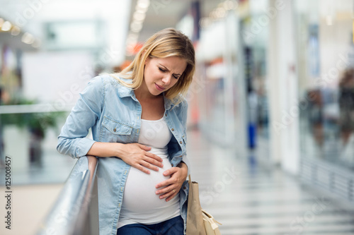 Fotografija Pregnant woman touching her belly, having pains