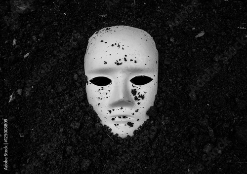 Fotografie White mask in soil,Horror background for Halloween concept and book cover ideas