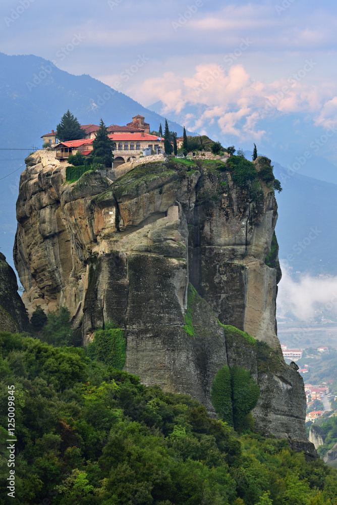 Meteora monasteries. Beautiful view on Monastery of the Holy Trinity placed on the edge of high rock covered of the morning at sun rises, Kastraki, Greece