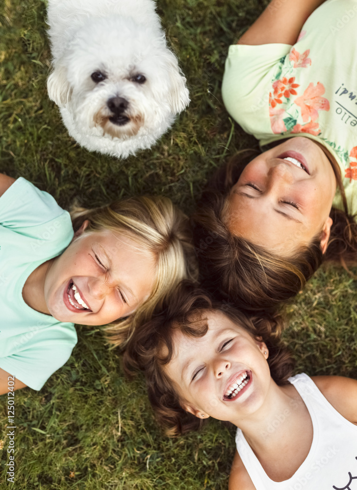 Three happy girls and a puppy on a meadow Three happy girls and a puppy on a meadow