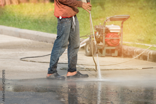 High pressure cleaning.Worker cleaning driveway with high pressure washer
