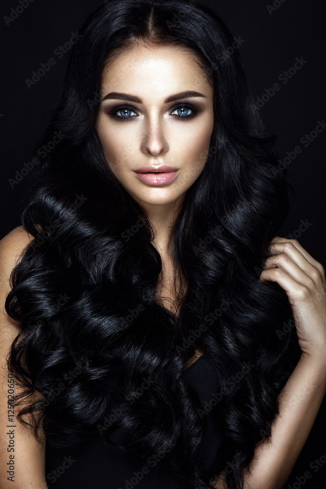 Beautiful woman portrait on black background. Glamour make up and curly hair.