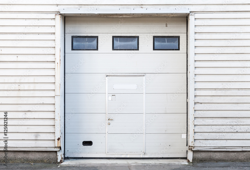 White warehouse wall with closed gate White warehouse wall with closed gate