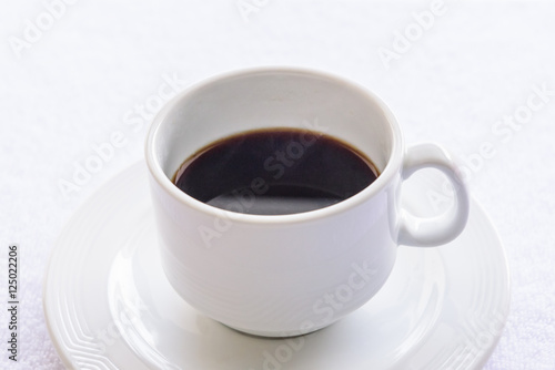 Black coffee cup on white towel