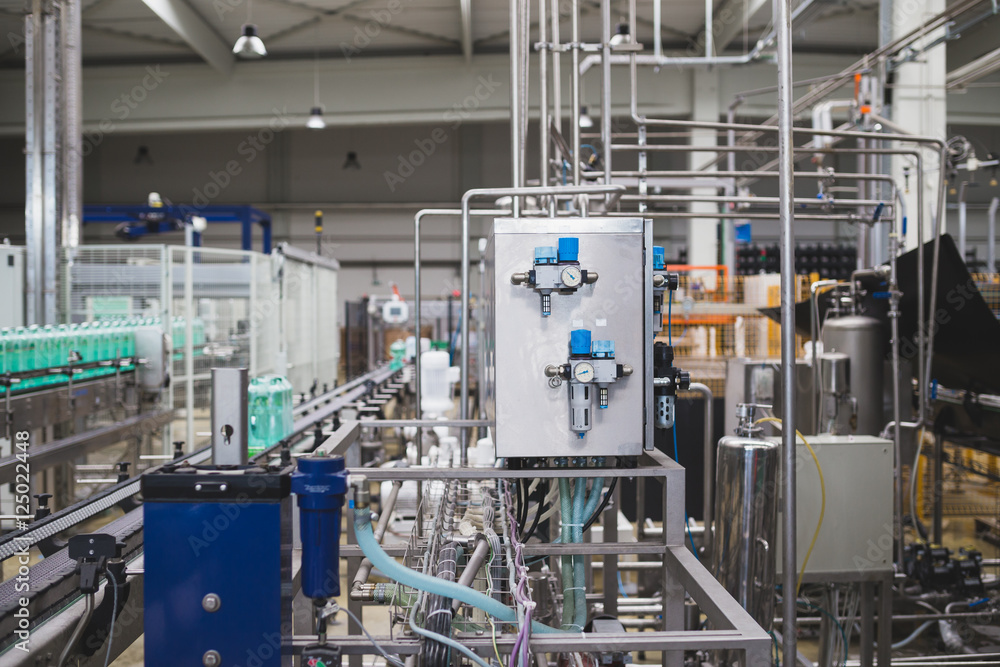 Industrial factory indoors and machinery. Robotic factory line for processing and bottling of pure spring water into canisters and bottles. Selective focus. Short depth of field. Industrial factory indoors and machinery. Robotic factory line for processing and bottling of pure spring water into canisters and bottles. Selective focus. Short depth of field.
