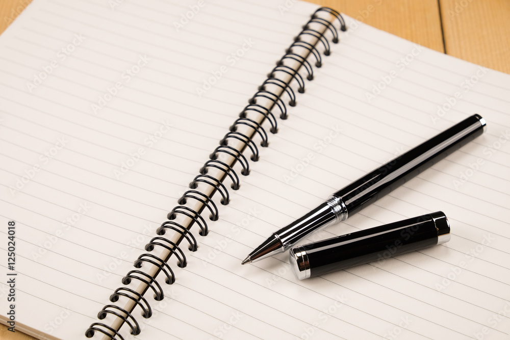 pen and book on wood background pen and book on wood background