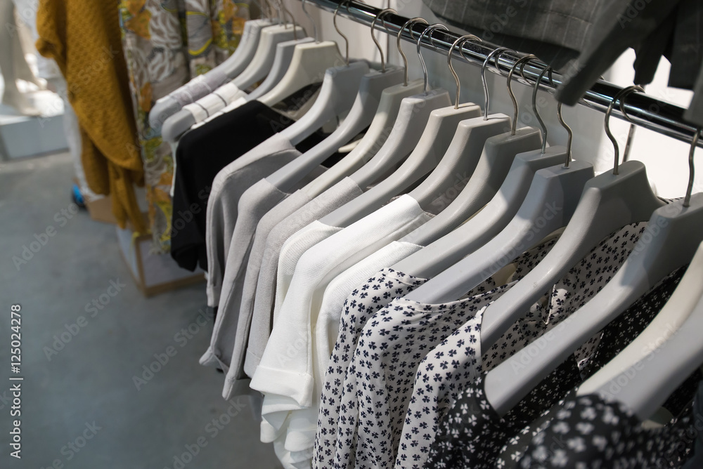 Fototapeta premium Clothes hang on a shelf in store