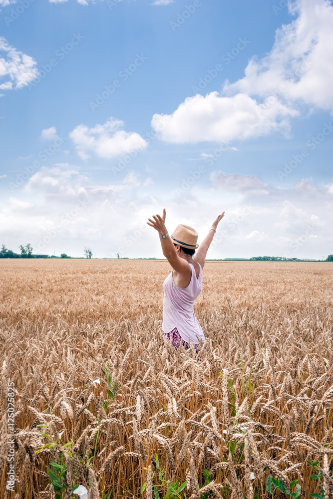 Woman enjoys the immensity chain with ripe wheat Woman enjoys the immensity chain with ripe wheat