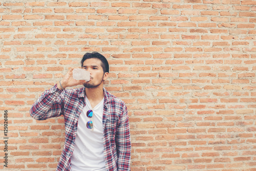 Young hipster bearded man with water bottle in plaid shirt in fr