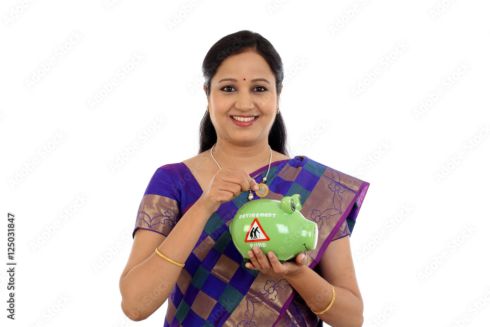 Young Indian traditional woman inserting a ten rupee coin Young Indian traditional woman inserting a ten rupee coin