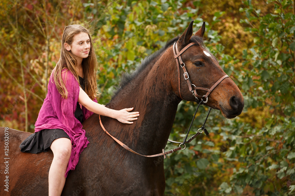 Fototapeta premium Mädchen mit Pferd vor Herbstlaub