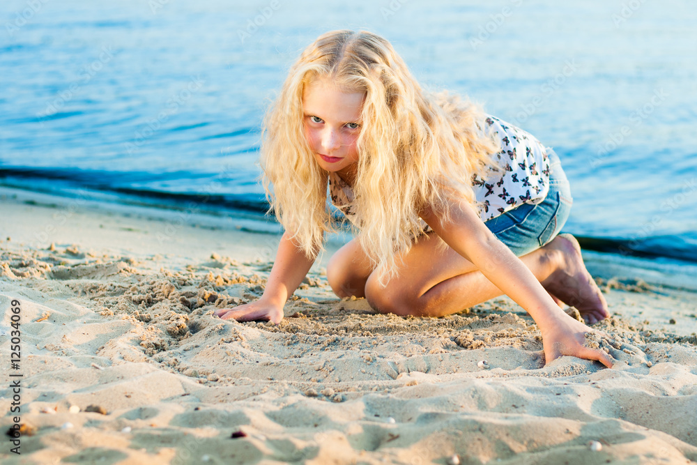 Fototapeta premium Girl on the sand near the water
