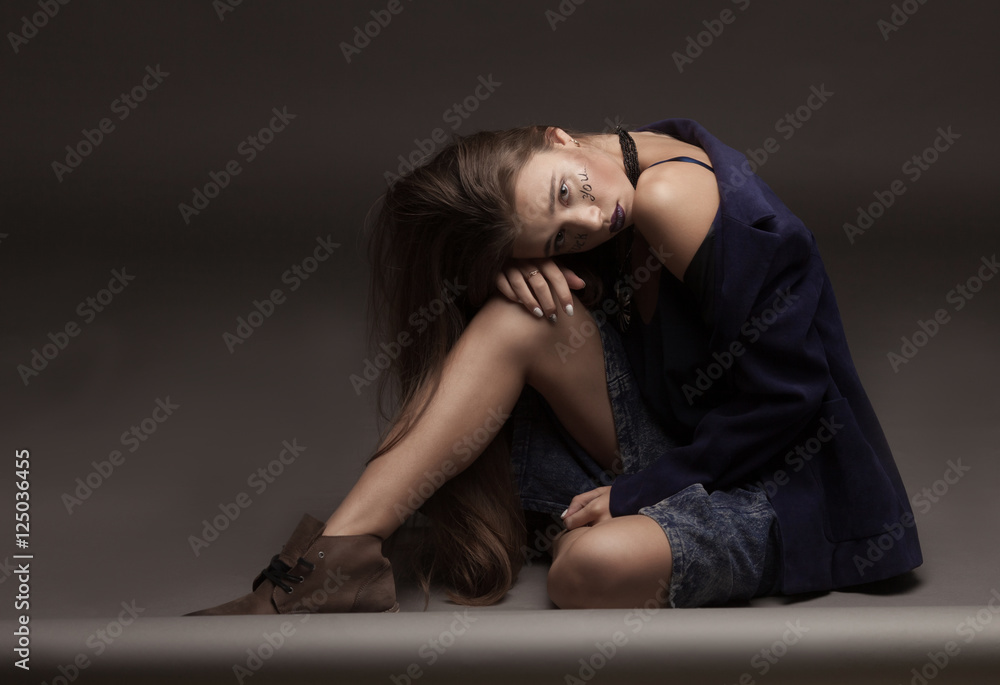 sexy fashion model with natural brunette hair, long legs, full lips, perfect skin, wearing brown shoes and long jeans skirt, sitting on floor, beauty photoshoot. Woman with creative make. sexy fashion model with natural brunette hair, long legs, full lips, perfect skin, wearing brown shoes and long jeans skirt, sitting on floor, beauty photoshoot. Woman with creative make.