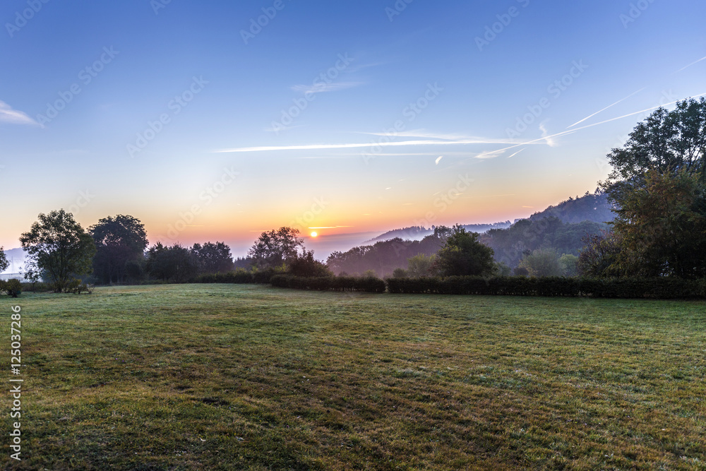 Obraz premium sunrise in german countryside with hills in the Eifel