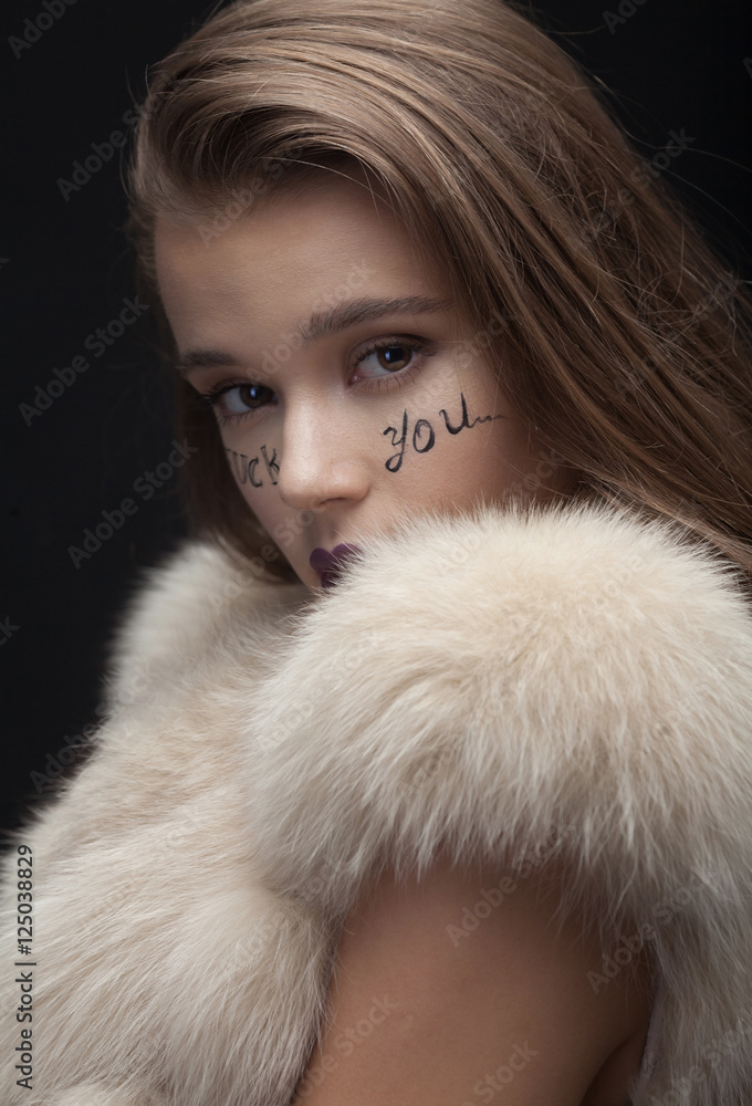 Beauty Fashion Model Girl in Blue Mink Fur Coat. Beautiful Luxury Winter Woman with creative make writing fuck you on face Beauty Fashion Model Girl in Blue Mink Fur Coat. Beautiful Luxury Winter Woman with creative make writing fuck you on face