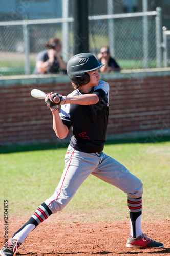 Teenage baseball player at bat