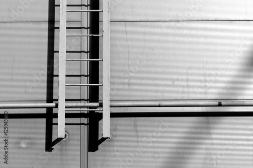 Fotografía Black and white Ladder on grey wall.