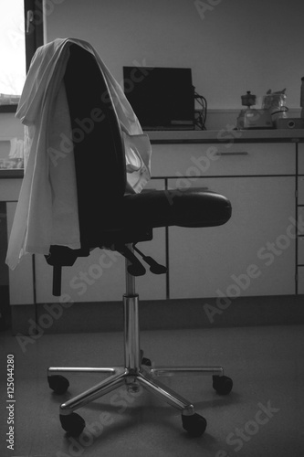 Empty laboratory chair with lab coat