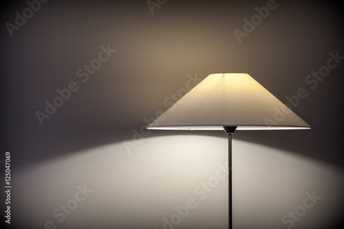 Hotel room lamp projecting light and  shade on the wall
