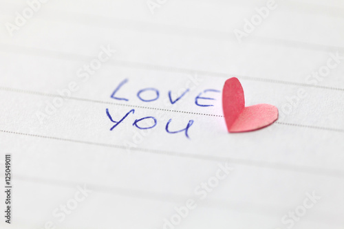 Handwritten phrase "LOVE YOU" with heart. Shallow depth of field.