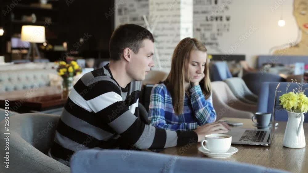 Boy and girl in cafe. People use laptop and smartphones, talk and drink coffee. Boy and girl in cafe. People use laptop and smartphones, talk and drink coffee.