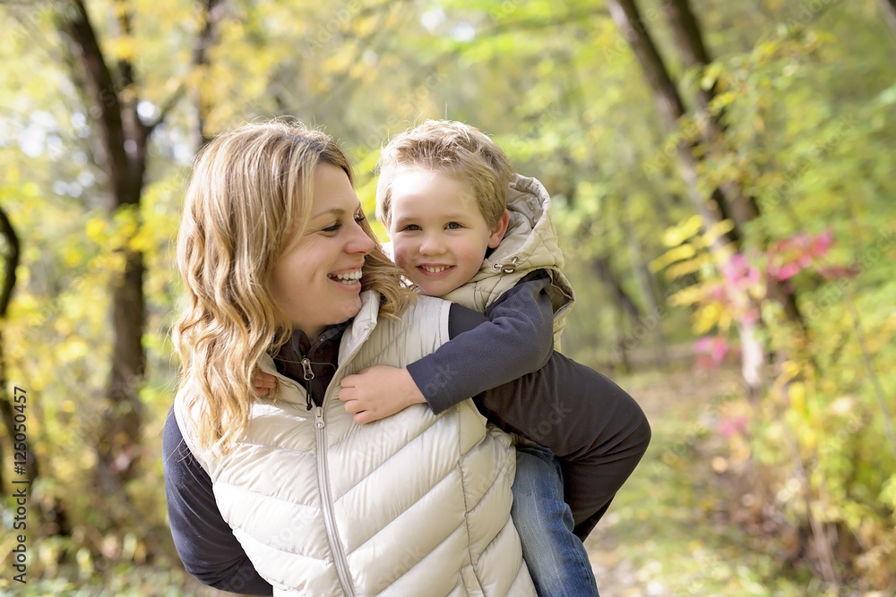 Adorable little boy with his mother in autumn park Adorable little boy with his mother in autumn park