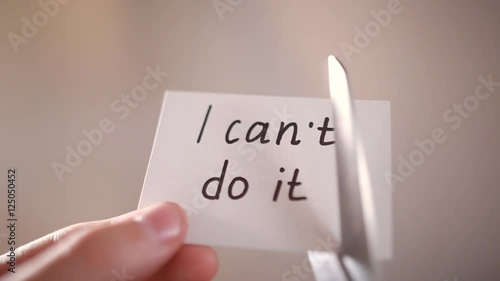 Man using scissors to remove the word can't to read I can do it concept for self belief, positive attitude and motivation photo