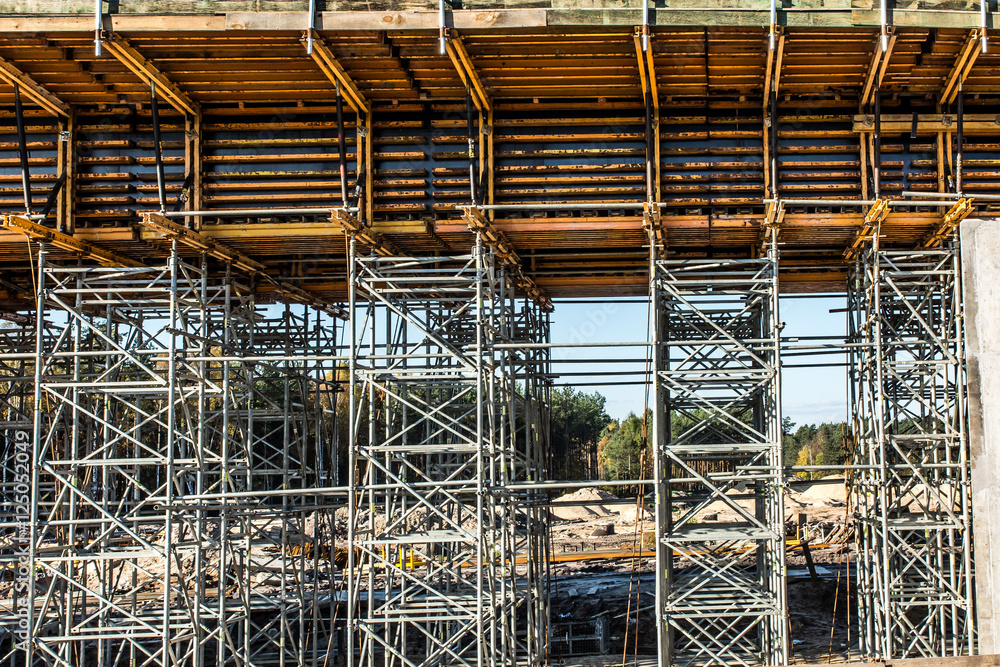 .construction scaffolding built under an overpass over the highw