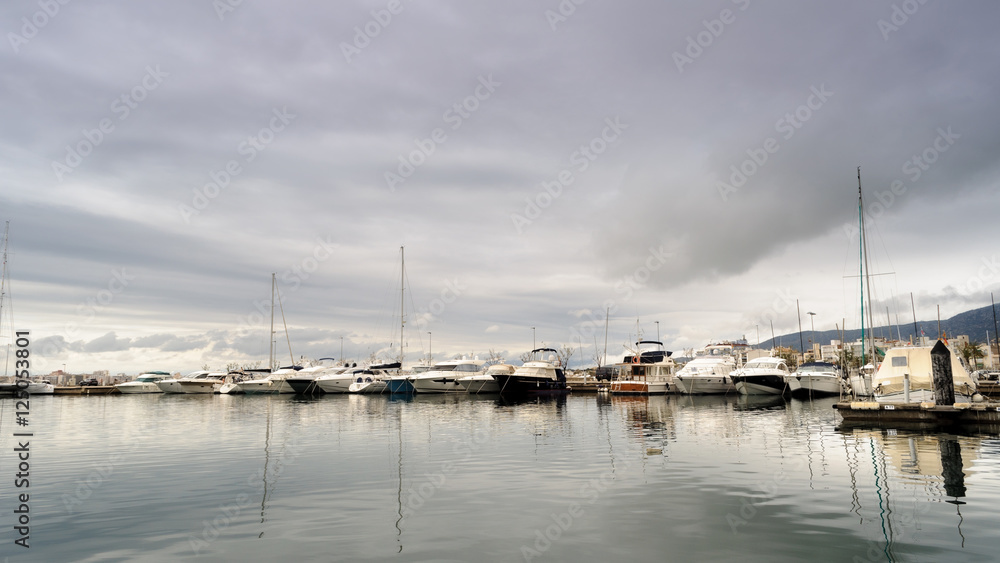 Reflejos en el  puerto de Rosas en un día nublado