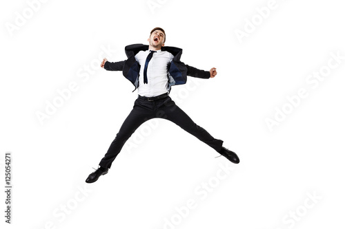 Young successful businessman in suit rejoicing, jumping over white background.
