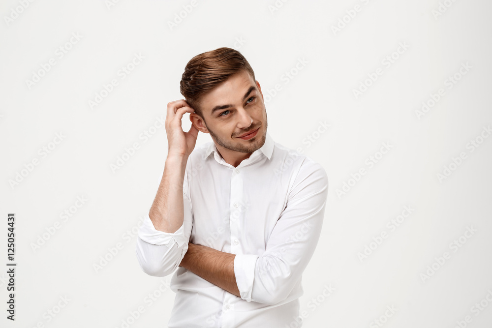 Young successful businessman thinking, posing over white background.