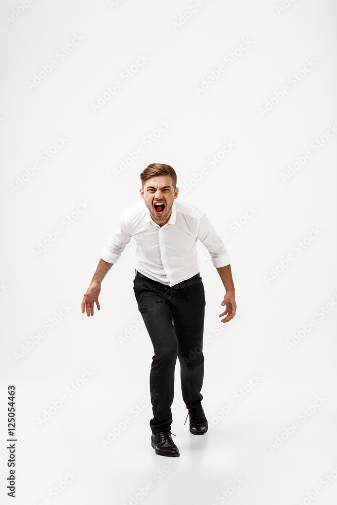 Young successful businessman in suit shouting over white background. Young successful businessman in suit shouting over white background.